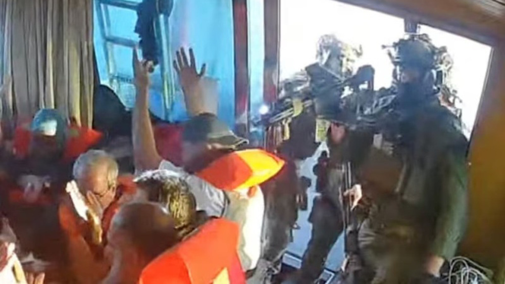 Global Sumud Flotilla activists in life vests raising hands as Israeli navy soldiers board their vessel in international waters, May 2026