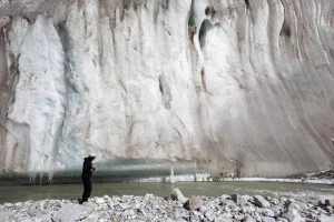 Melting glaciers in Pakistan's Karakoram mountain range with glacial lake forming in the valley below