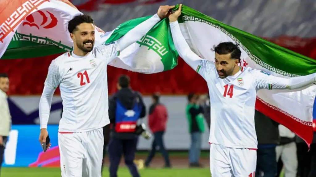 Iran national football team players during their FIFA World Cup 2026 match against New Zealand in front of a packed stadium crowd.