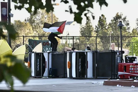 Pro Palestine campus protesters holding Palestinian flags and signs during a rally in the United States