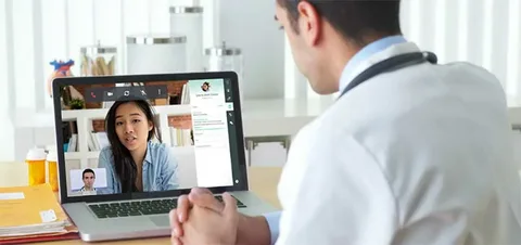 Healthcare worker using a telehealth system to provide remote medical consultation to a patient in rural Zimbabwe.
