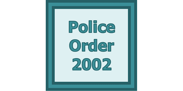Pakistani police officers reviewing the Police Order 2002 legal document