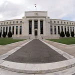 Wall Street traders watching a screen showing the US Federal Reserve interest rate decision