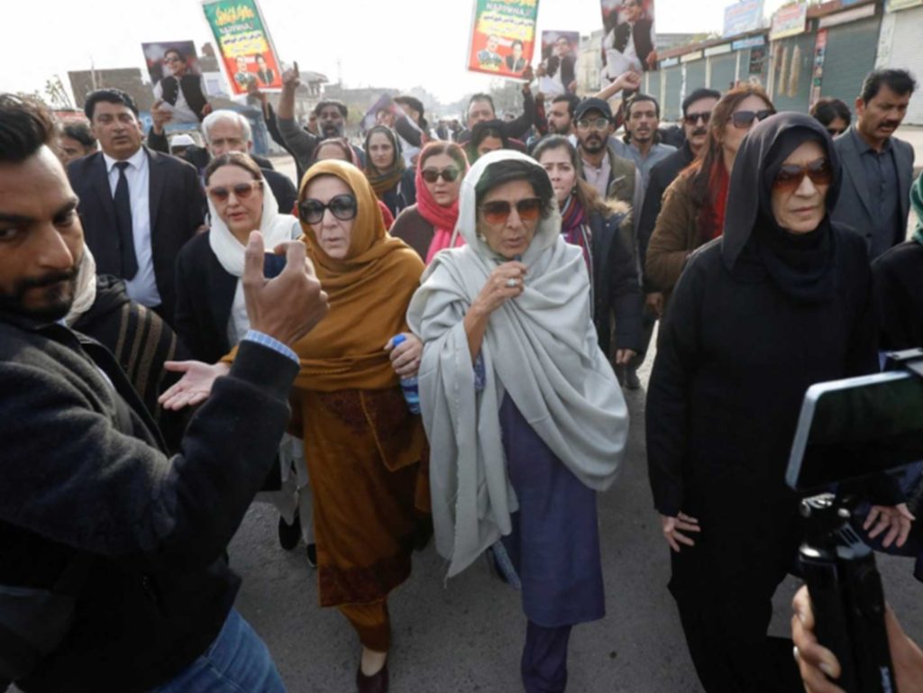 PTI supporters and family members of Imran Khan gathered near a police vehicle in Lahore