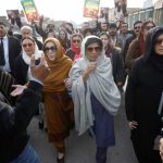 PTI supporters and family members of Imran Khan gathered near a police vehicle in Lahore