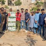 Volunteers plant fruit tree saplings at a fruit orchard initiative in Malir, Karachi.