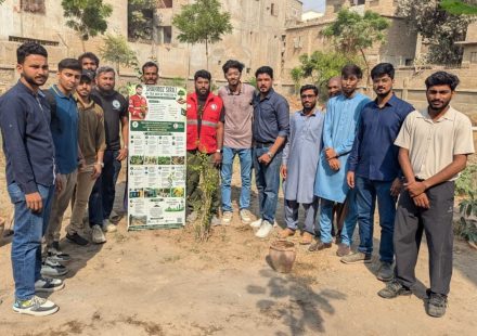 Volunteers plant fruit tree saplings at a fruit orchard initiative in Malir, Karachi.