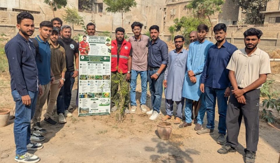 Volunteers plant fruit tree saplings at a fruit orchard initiative in Malir, Karachi.