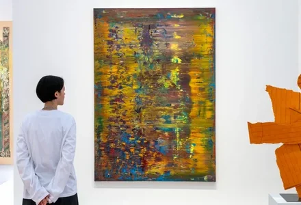 Young Gen Z art collectors viewing paintings at an Art Basel fair as a new UBS report shows record spending