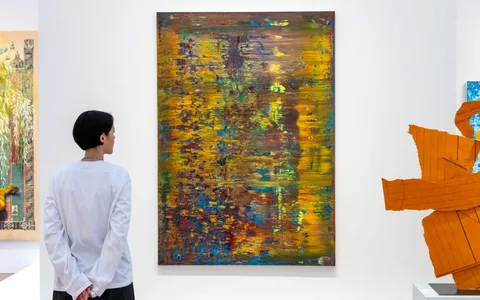 Young Gen Z art collectors viewing paintings at an Art Basel fair as a new UBS report shows record spending